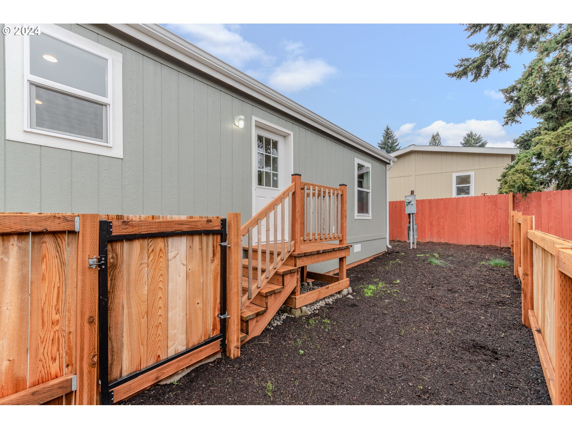 9700 Southwest Tualatin Road, Unit 39 Tualatin, OR 97062 - Photo 24 of 28 a backyard of a house with wooden fence and deck