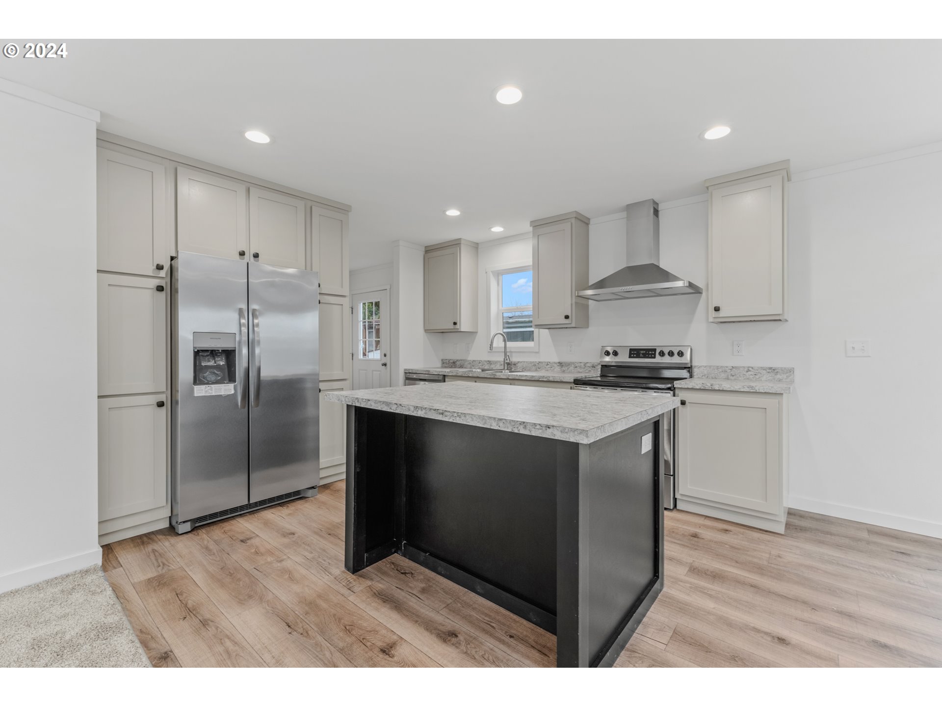 9700 Southwest Tualatin Road, Unit 39 Tualatin, OR 97062 - Photo 9 of 28 a kitchen with kitchen island granite countertop a sink cabinets and stainless steel appliances