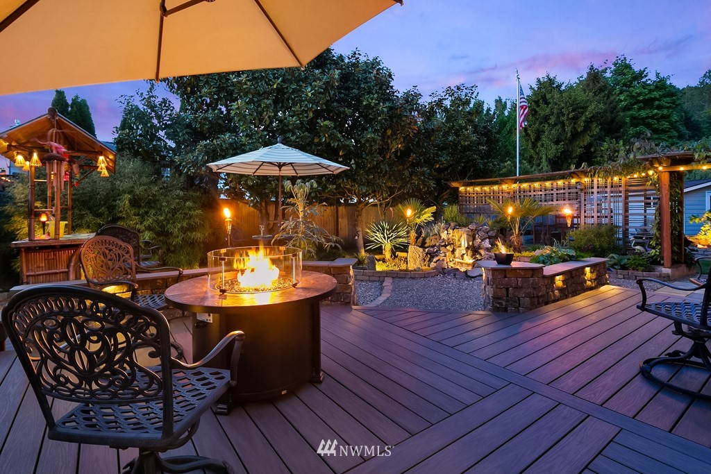 932 South 32nd Place Renton, WA 98055 - Photo 2 of 31 a view of a roof deck with table and chairs under an umbrella