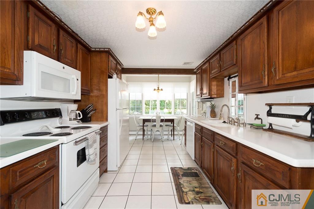 5 Utica Road Edison, NJ 08820 - Photo 5 of 48 a kitchen with a stove a sink and a refrigerator