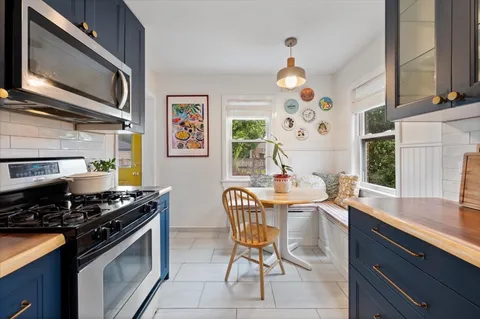 a kitchen with stainless steel appliances granite countertop a stove a sink and a microwave