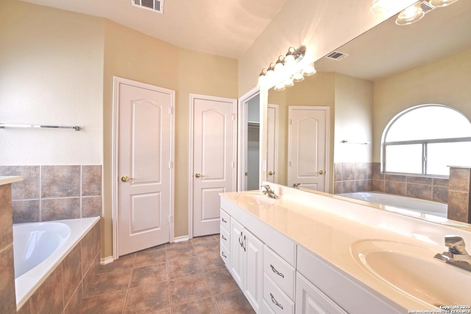 25303 Mesa Ranch San Antonio, TX 78258 - Photo 37 of 54 a spacious bathroom with a bathtub sink and mirror