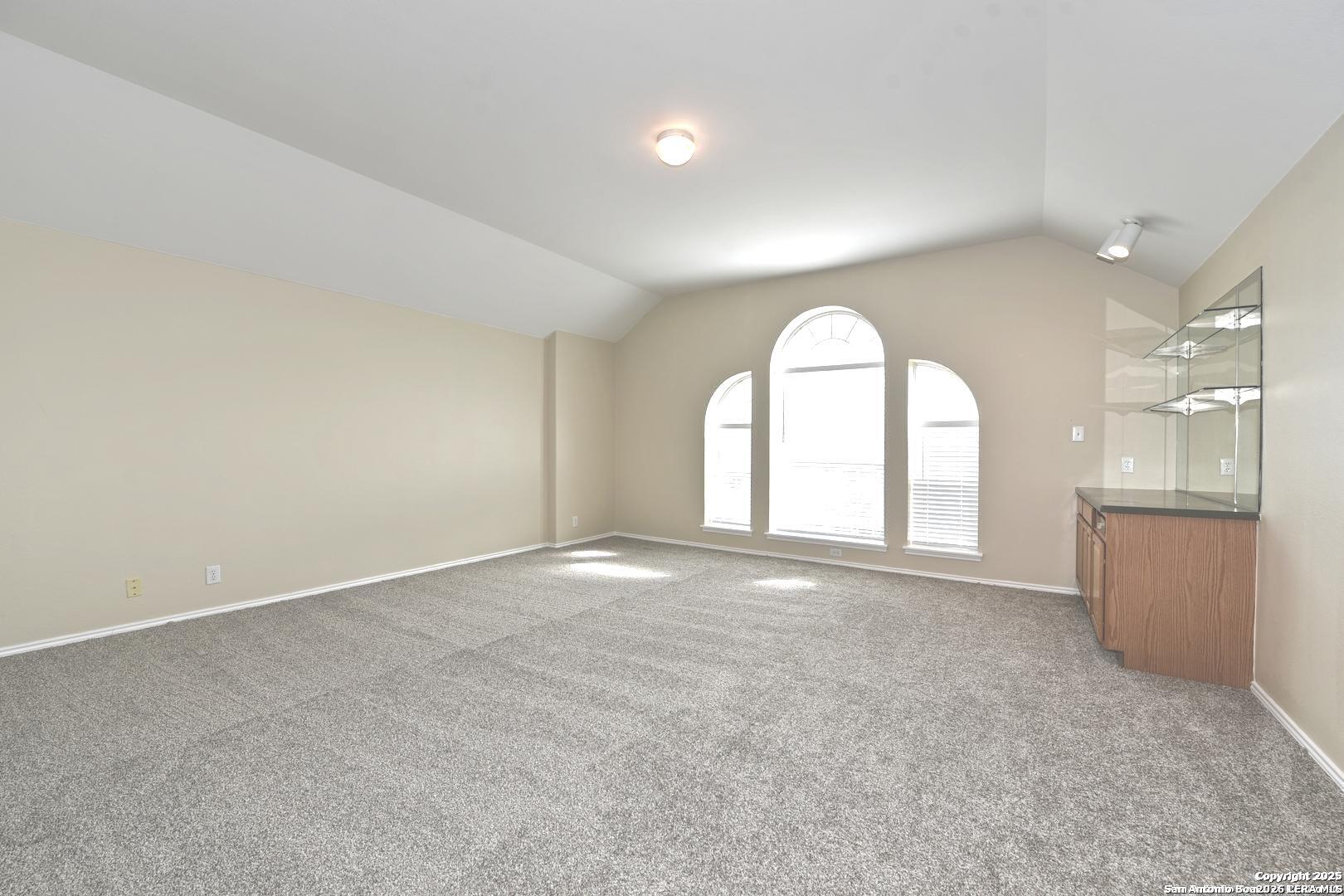25303 Mesa Ranch San Antonio, TX 78258 - Photo 41 of 54 an empty room with a fireplace and windows