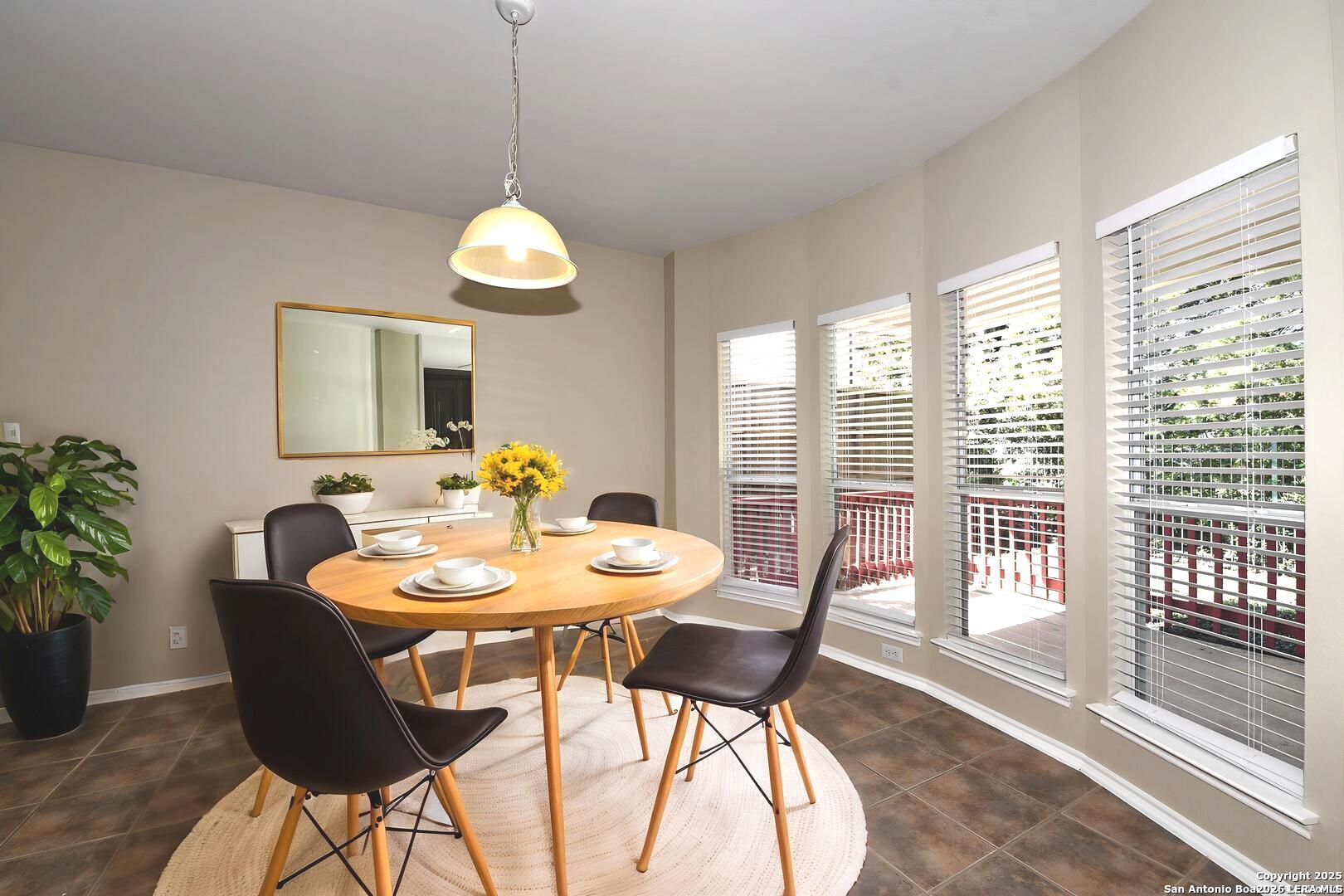 25303 Mesa Ranch San Antonio, TX 78258 - Photo 7 of 54 a dining room with furniture wooden floor and a chandelier