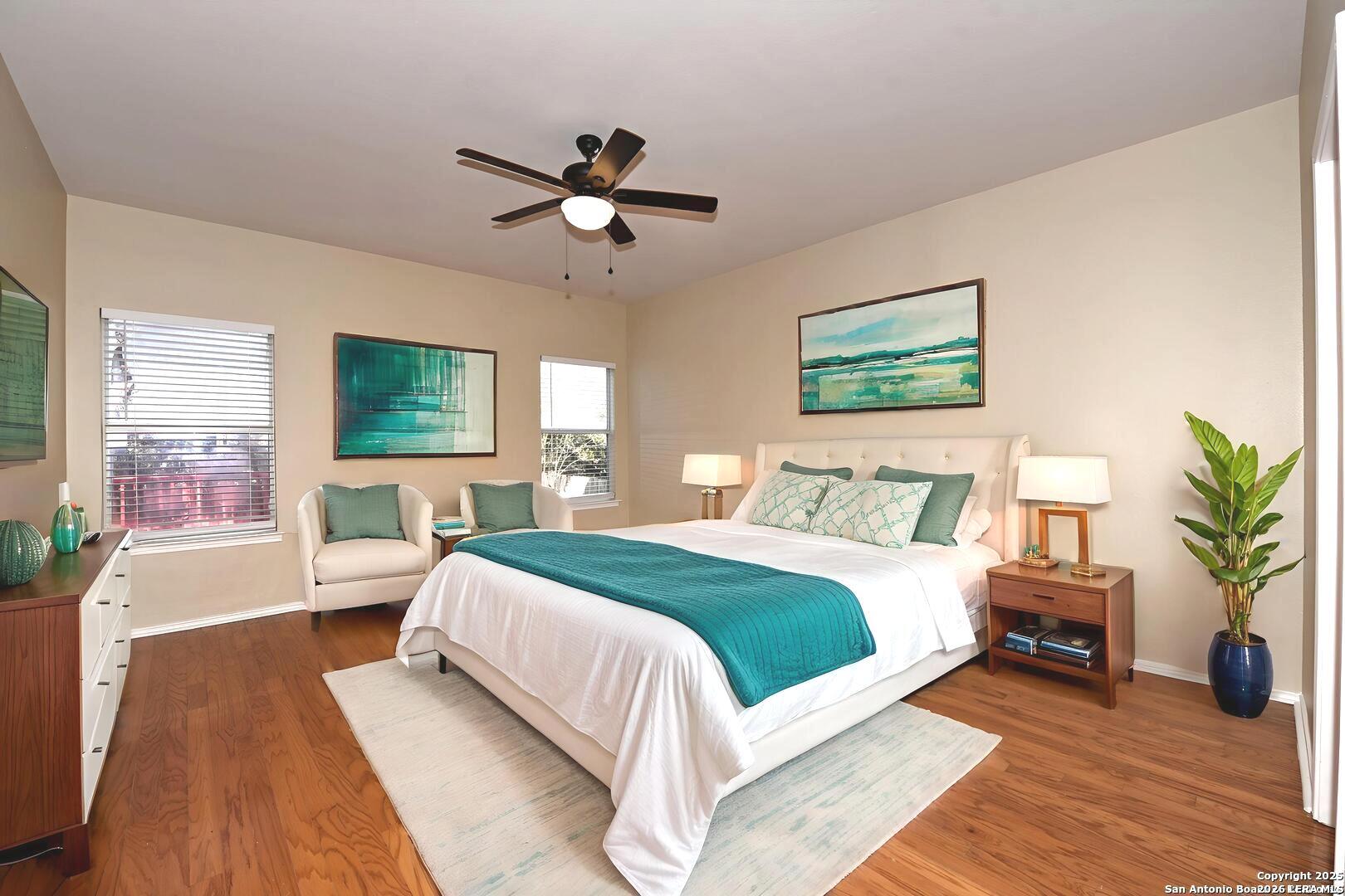 25303 Mesa Ranch San Antonio, TX 78258 - Photo 9 of 54 a bedroom with a large bed a chandelier and windows