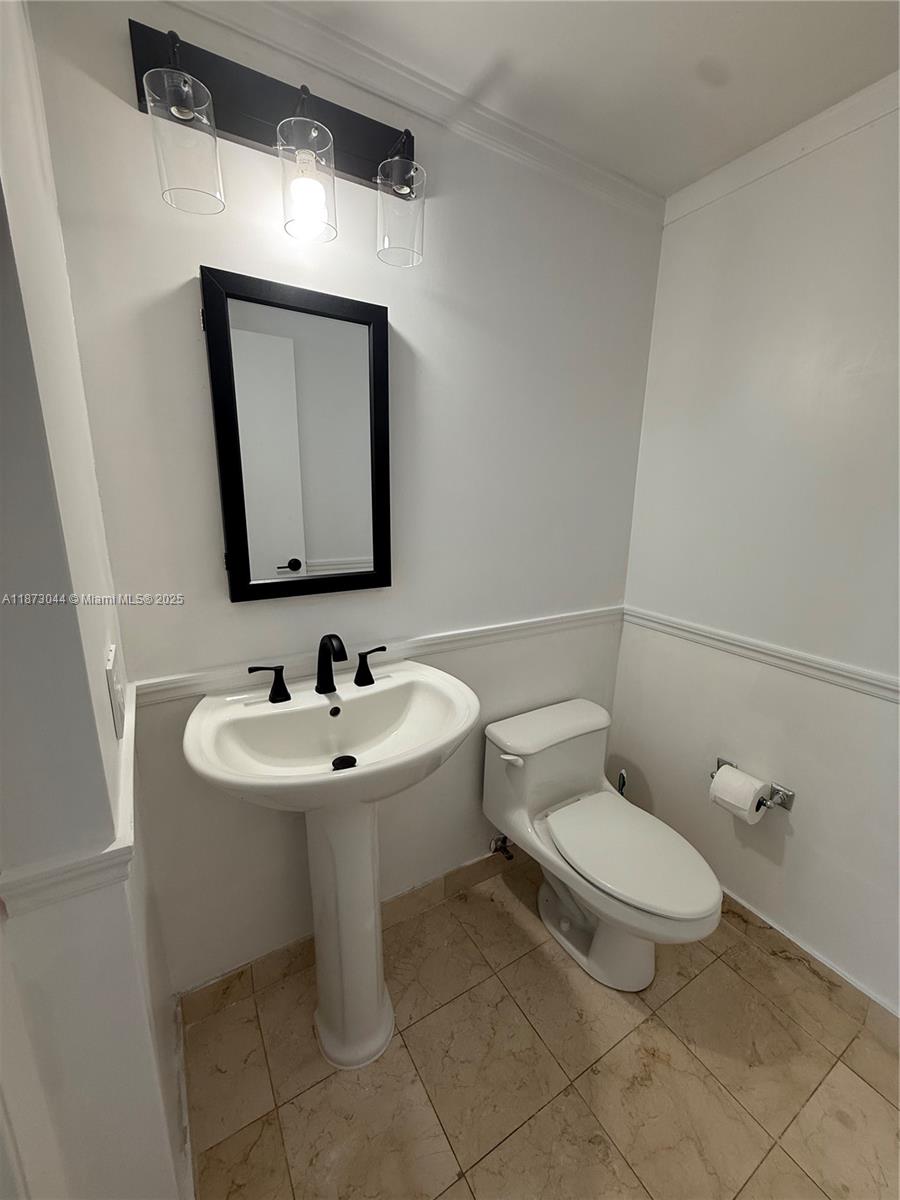 6365 Collins Avenue, Unit 904 Miami Beach, FL 33141 - Photo 22 of 25 a bathroom with a toilet sink and mirror