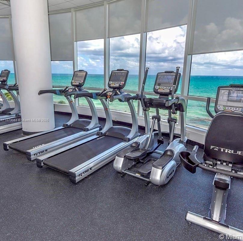 6365 Collins Avenue, Unit 904 Miami Beach, FL 33141 - Photo 3 of 25 a room with gym equipment and a large window