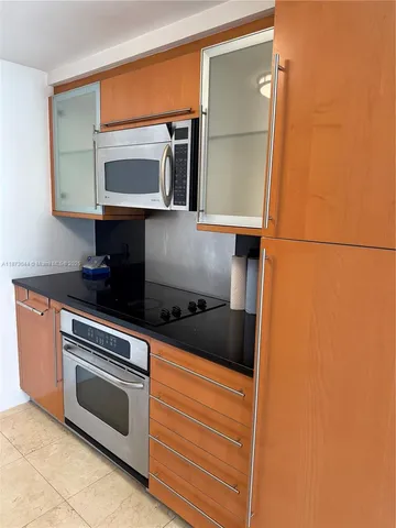 a kitchen with granite countertop cabinets stainless steel appliances and a counter space