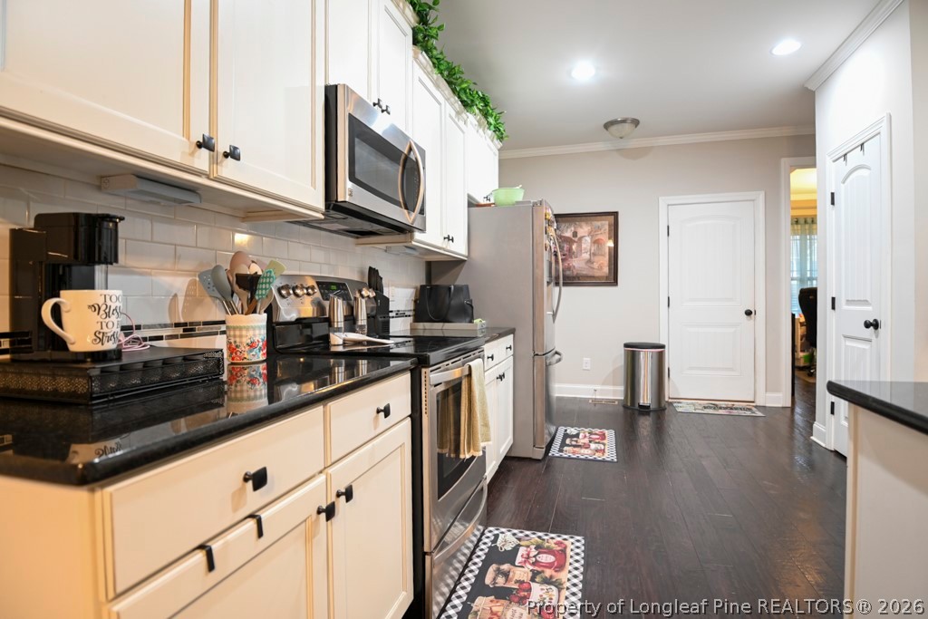 95 Valley Brook Lane Spring Lake, NC 28390 - Photo 12 of 34 a kitchen with stainless steel appliances granite countertop a refrigerator a stove a sink dishwasher and white cabinets with wooden floor