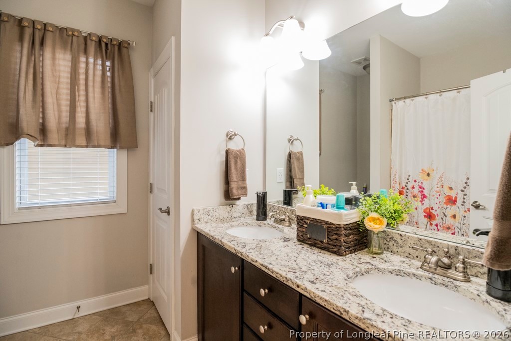 95 Valley Brook Lane Spring Lake, NC 28390 - Photo 27 of 34 a bathroom with a granite countertop sink and a mirror