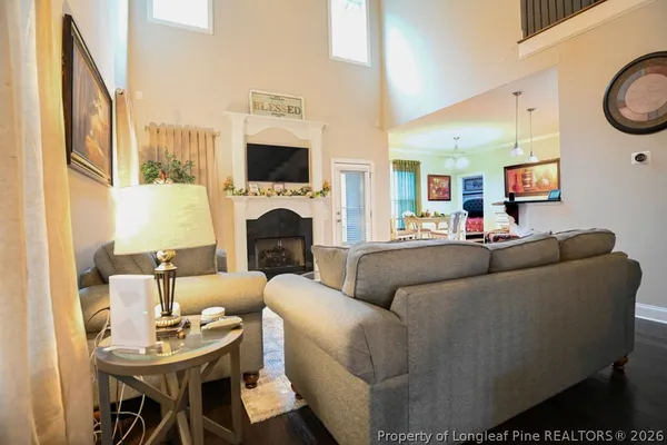 a living room with furniture a fireplace and a flat screen tv