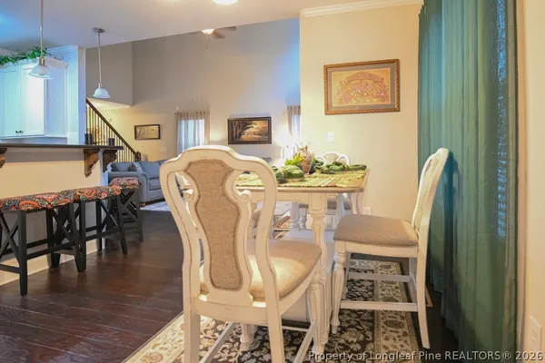 a dining room with furniture wooden floor a rug and a chandelier