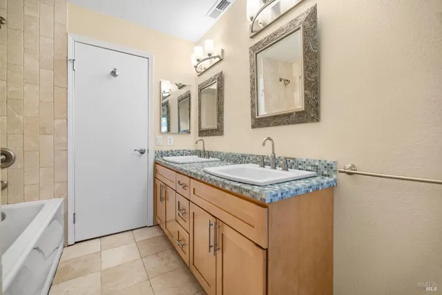 a bathroom with a granite countertop sink and a mirror