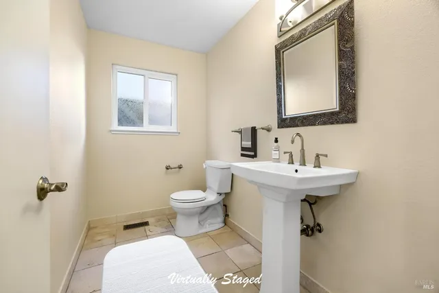 a bathroom with a toilet sink and mirror