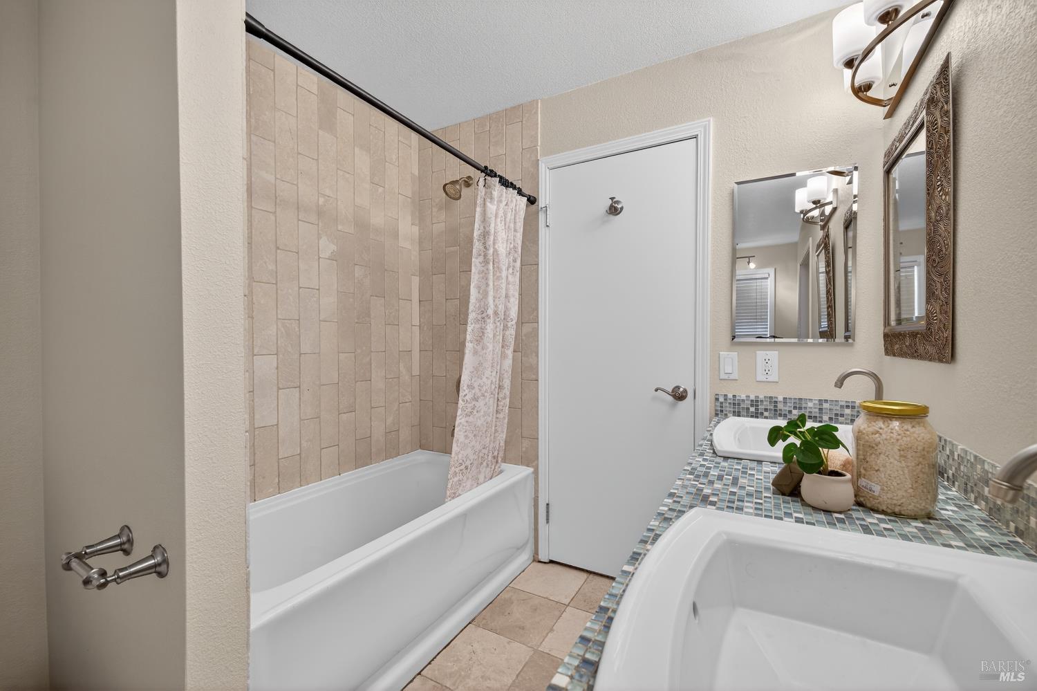 985 Hacienda Circle Rohnert Park, CA 94928 - Photo 27 of 36 a bathroom with a granite countertop sink a mirror a bathtub and shower