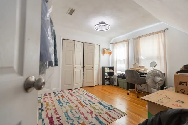 a bedroom with a bed and wooden floor