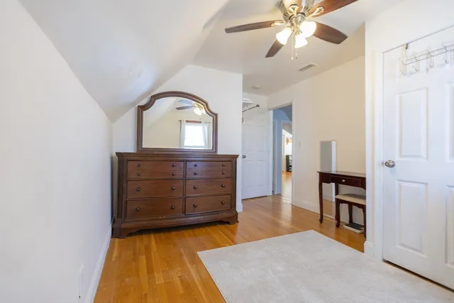 wooden floor with a chandelier and a dresser