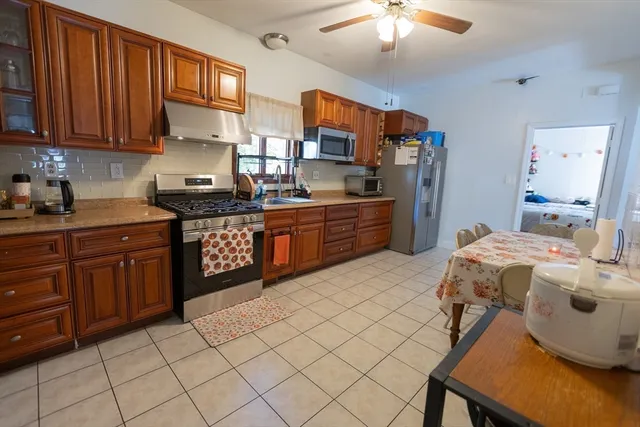 a kitchen with stainless steel appliances granite countertop a sink a stove and a refrigerator