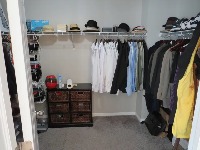 a view of walk in closet with clothes and shoes