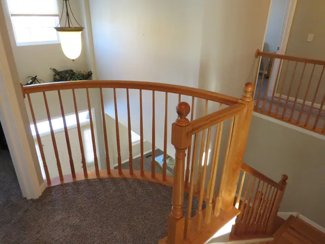 a view of staircase with railing and a window
