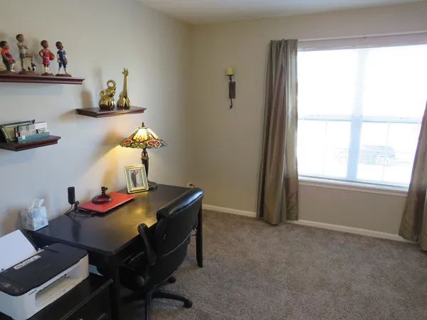 a view of a workspace with furniture and a window