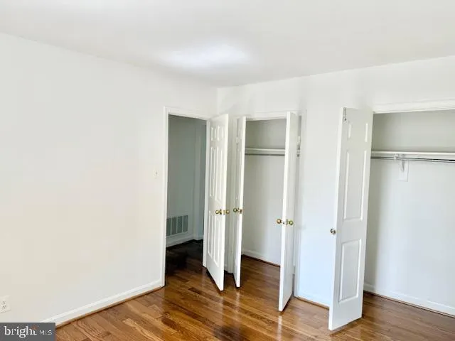 an empty room with wooden floor and entrance