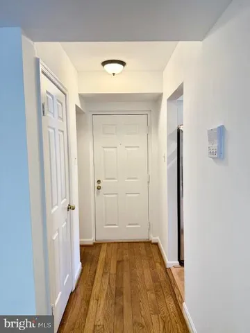 a view of a hallway with wooden floor and entryway