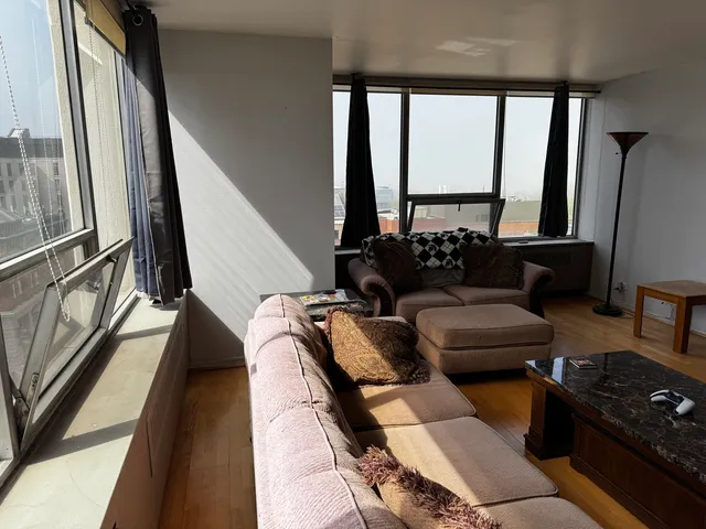 a living room with furniture and a floor to ceiling window