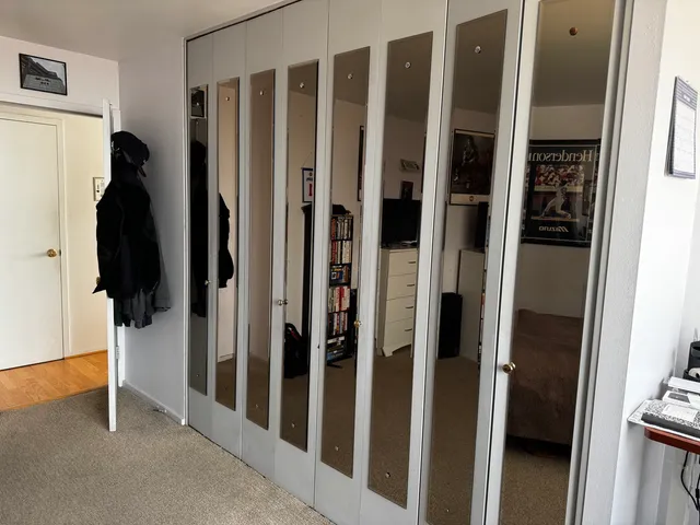 a view of walk in closet with clothes and white walls