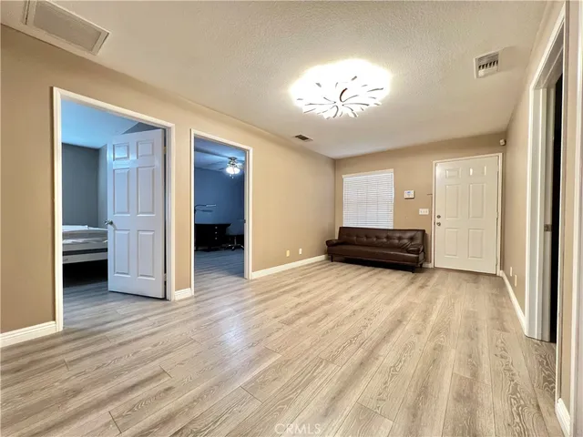 an empty room with wooden floor and chandelier