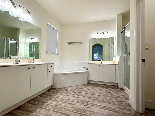 a bathroom with a sink mirror and a bathtub