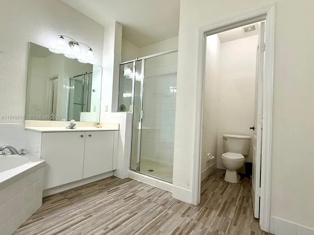 a bathroom with a granite countertop sink mirror and a toilet