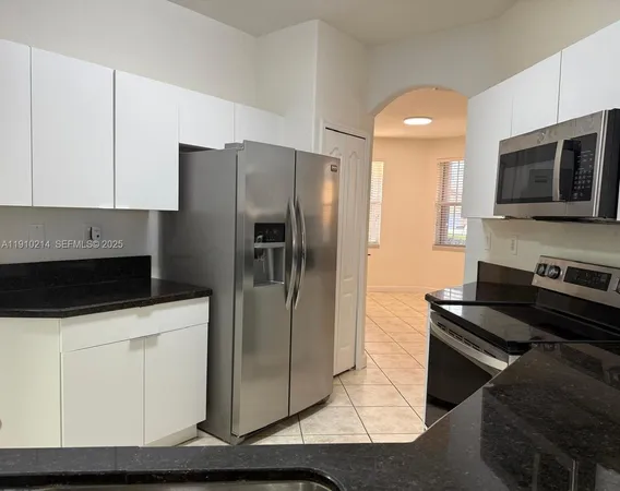 a kitchen with stainless steel appliances a refrigerator a stove a microwave and cabinets