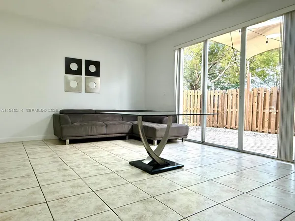 a living room with a black white checkered floor with a gaming machine and a rug