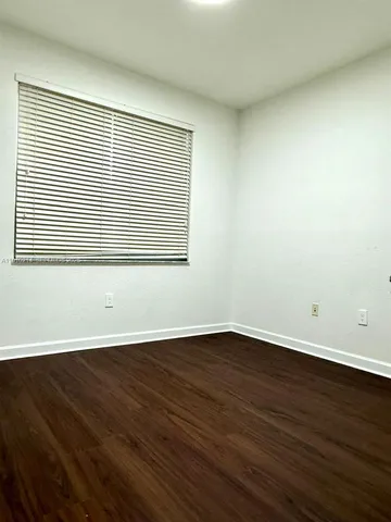an empty room with wooden floor and a window