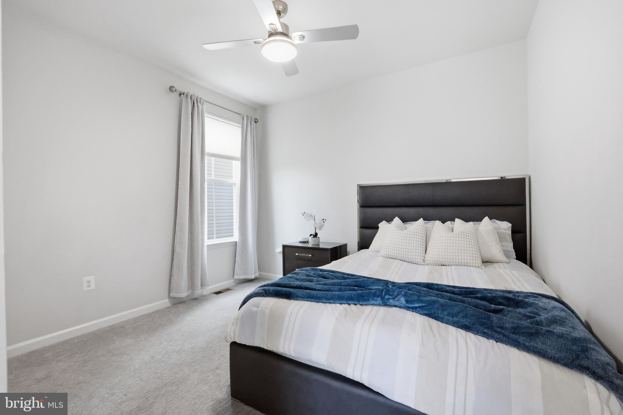 5707 Hawk Ridge Road Frederick, MD 21704 - Photo 30 of 109 a bedroom with a large bed and a chandelier