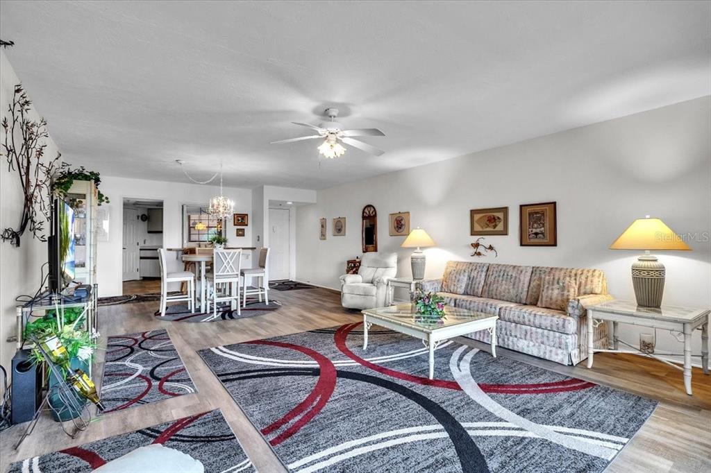 23465 Harbor View Road, Unit 723 Port Charlotte, FL 33980 - Photo 9 of 42 a living room with furniture a chandelier and a rug