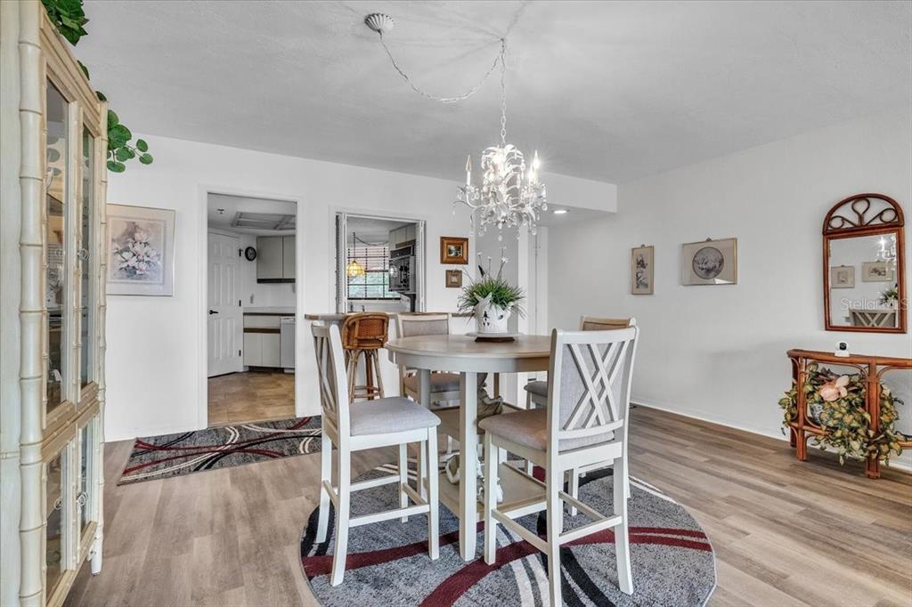 23465 Harbor View Road, Unit 723 Port Charlotte, FL 33980 - Photo 10 of 42 a view of a dining room with furniture and wooden floor