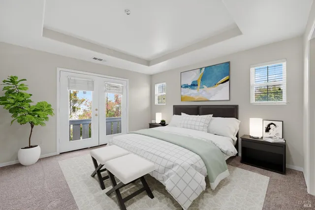 a bedroom with a large bed and a potted plant