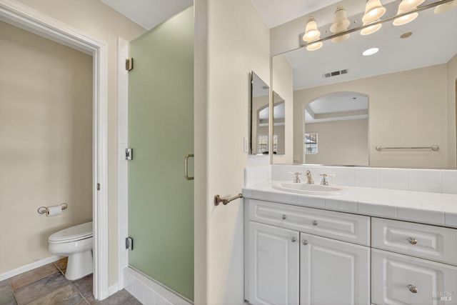 a bathroom with a toilet a sink a mirror and a shower