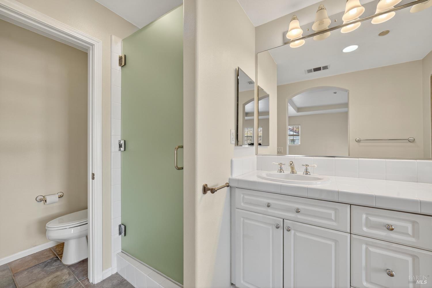 23 Greenham Court Novato, CA 94949 - Photo 17 of 20 a bathroom with a toilet a sink a mirror and a shower