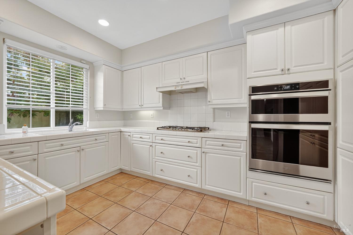 23 Greenham Court Novato, CA 94949 - Photo 6 of 20 a kitchen with granite countertop white cabinets and appliances