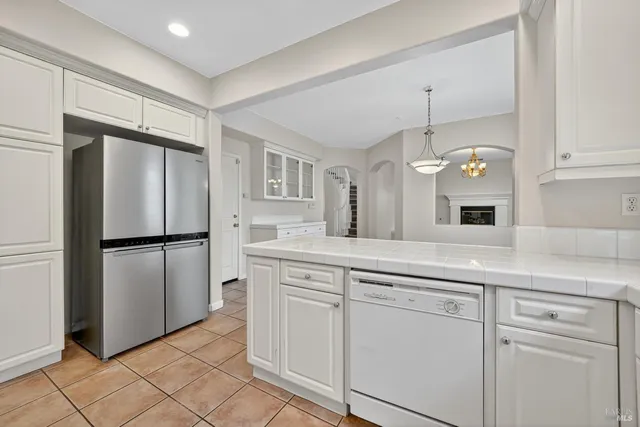 a kitchen with white cabinets and refrigerator
