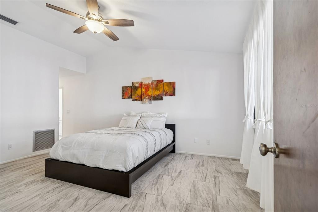 14301 86th Avenue North Seminole, FL 33776 - Photo 11 of 59 a bedroom with a bed and dresser