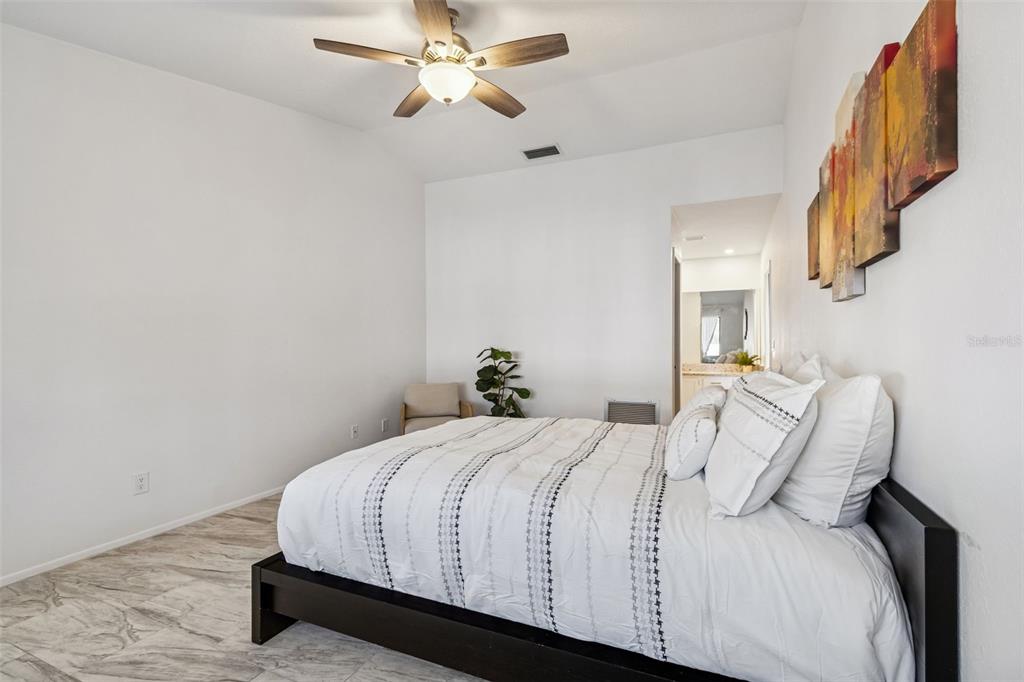 14301 86th Avenue North Seminole, FL 33776 - Photo 12 of 59 a bedroom with a bed and a chandelier