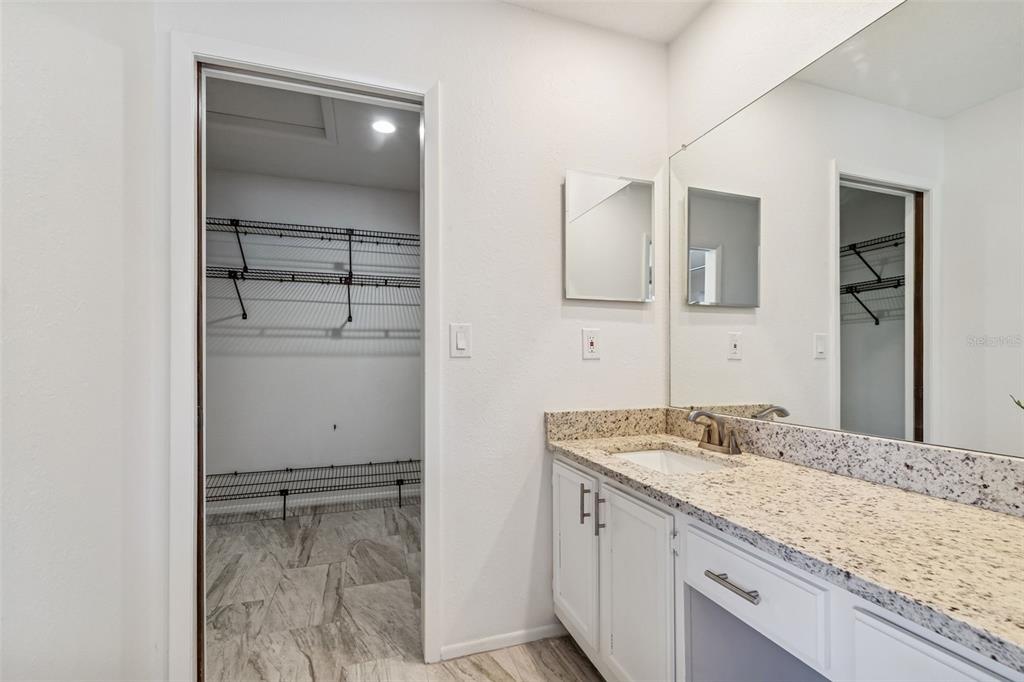 14301 86th Avenue North Seminole, FL 33776 - Photo 16 of 59 a bathroom with a granite countertop sink and a mirror