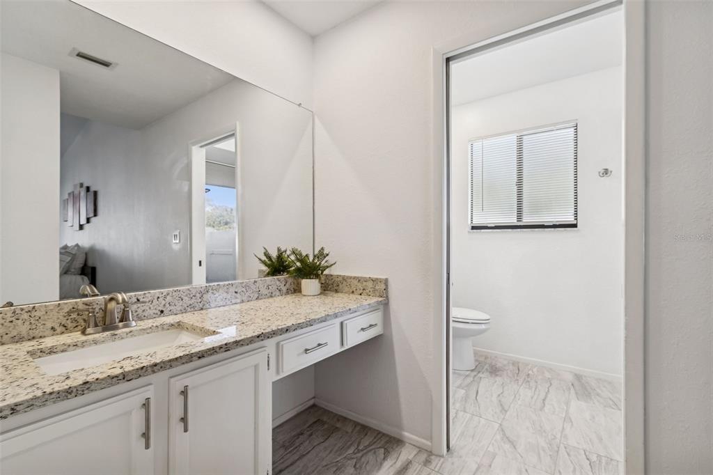 14301 86th Avenue North Seminole, FL 33776 - Photo 19 of 59 a bathroom with a granite countertop sink and a mirror