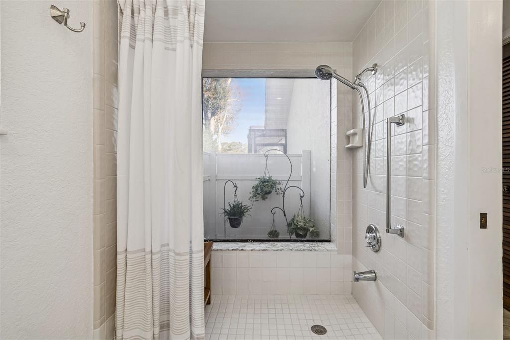 14301 86th Avenue North Seminole, FL 33776 - Photo 21 of 59 a bathroom with a shower and a bath tub