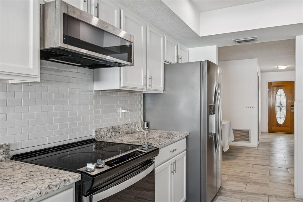 14301 86th Avenue North Seminole, FL 33776 - Photo 30 of 59 a kitchen with stainless steel appliances kitchen island a stove and a refrigerator