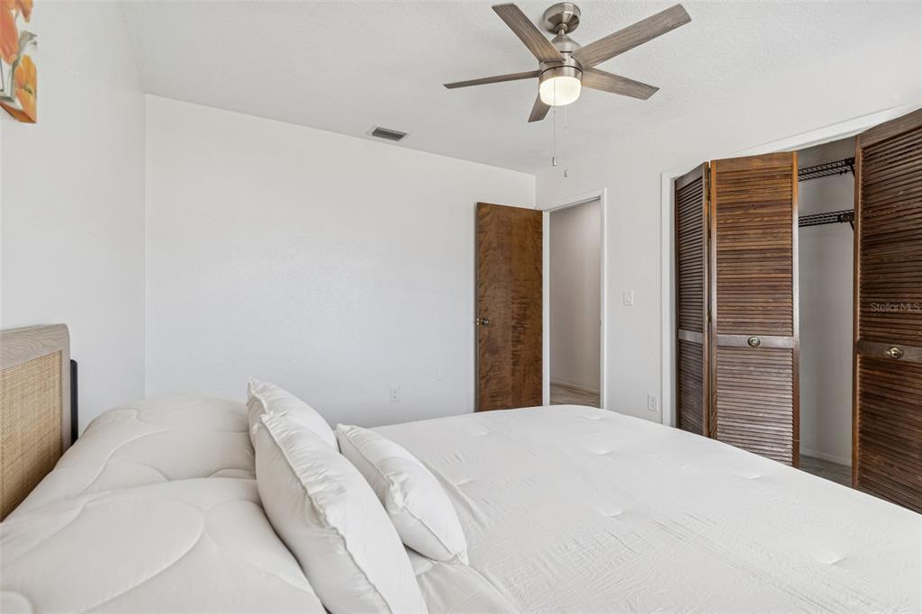 14301 86th Avenue North Seminole, FL 33776 - Photo 50 of 59 a bedroom with a bed and a ceiling fan